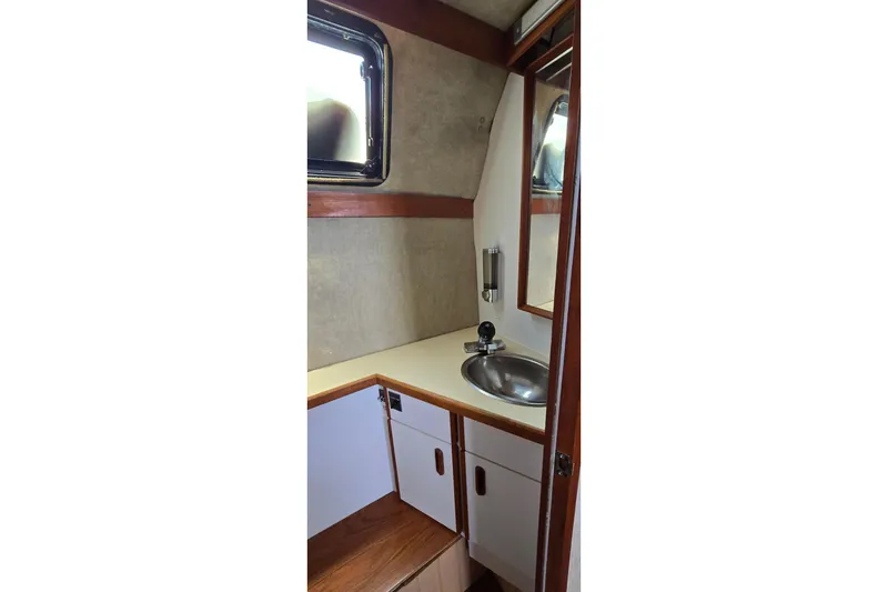 Slide: The Image of 1985 Carver 3207 Aft Cabin Motor Yacht bathroom with sink and storage cabinets. - 27