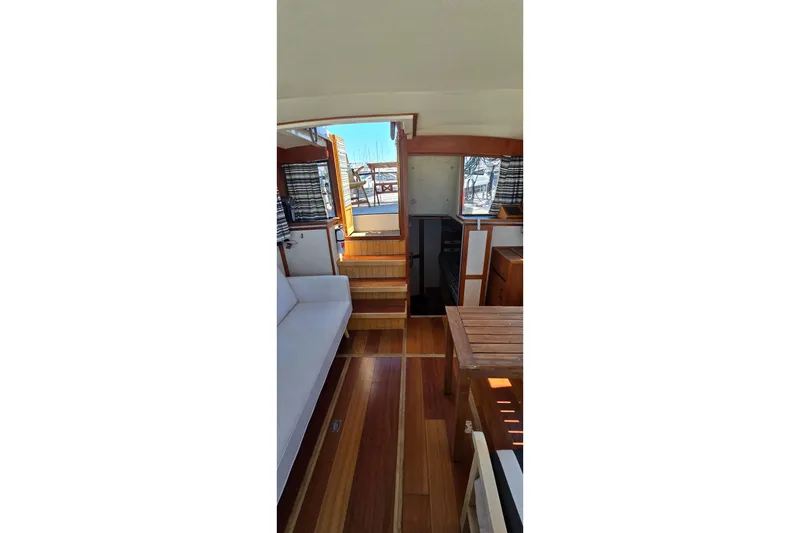 Slide: The Image of Interior of 1985 Carver 3207 Aft Cabin Motor Yacht with wooden flooring and seating area. - 29
