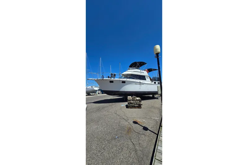 Slide: The Image of 1985 Carver 3207 Aft Cabin Motor Yacht on dry dock under clear blue sky. - 3
