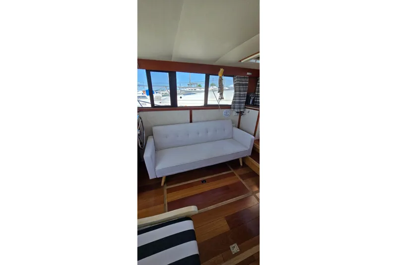 Slide: The Image of Interior of 1985 Carver 3207 Aft Cabin Motor Yacht with white sofa and wood flooring. - 30