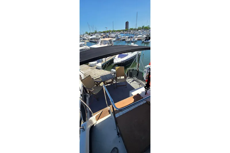 Slide: The Image of 1985 Carver 3207 Aft Cabin Motor Yacht docked at marina with chairs on deck. - 7