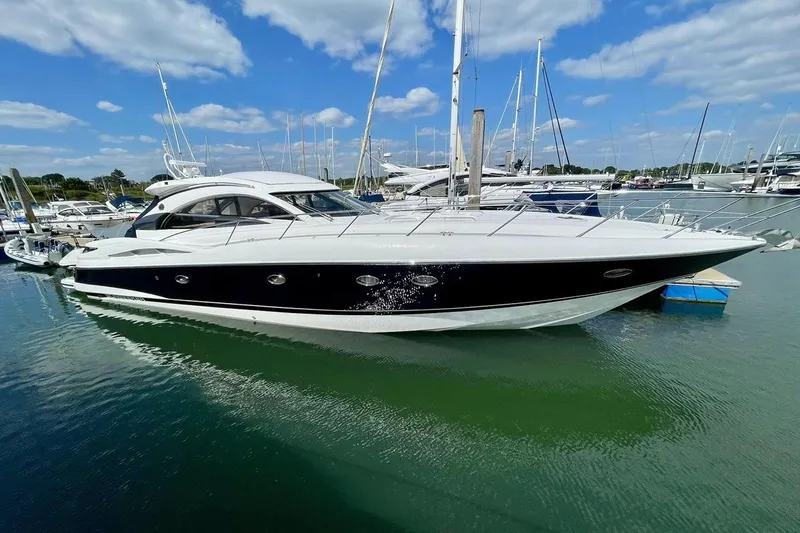 The Image of 2003 Sunseeker Predator 61 yacht docked in a marina under a blue sky. - 0