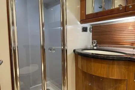 Slide: The Image of Luxurious bathroom in 2003 Sunseeker Predator 61 yacht with modern fixtures and wood accents. - 3