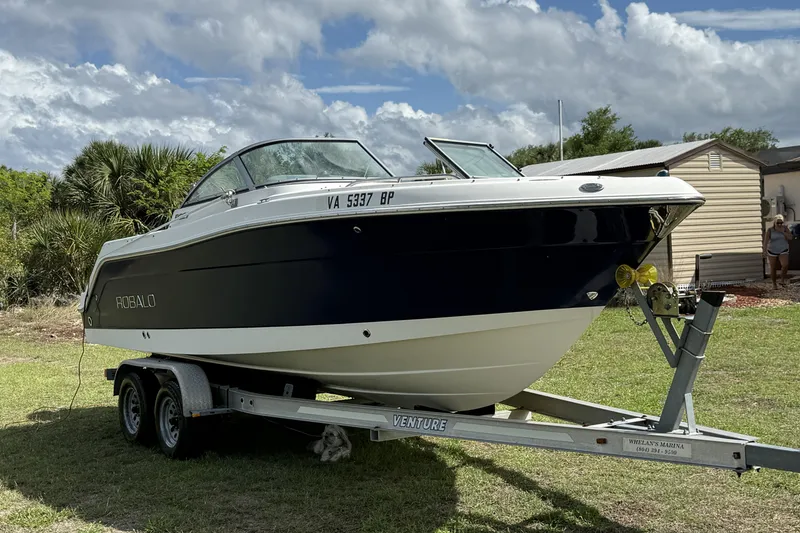 Slide: The Image of 2010 Robalo R227 Dual Console boat on trailer, parked on grass. - 2