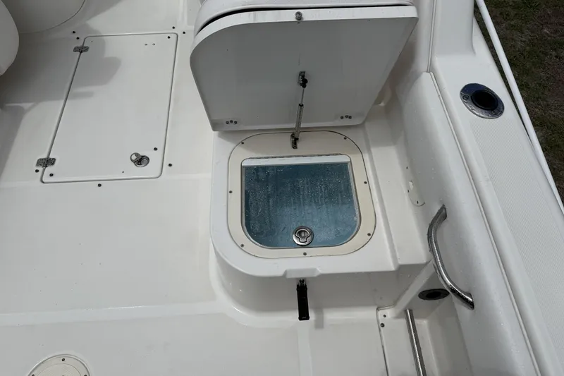 Slide: The Image of 2010 Robalo R227 Dual Console boat deck with storage compartment open. - 6