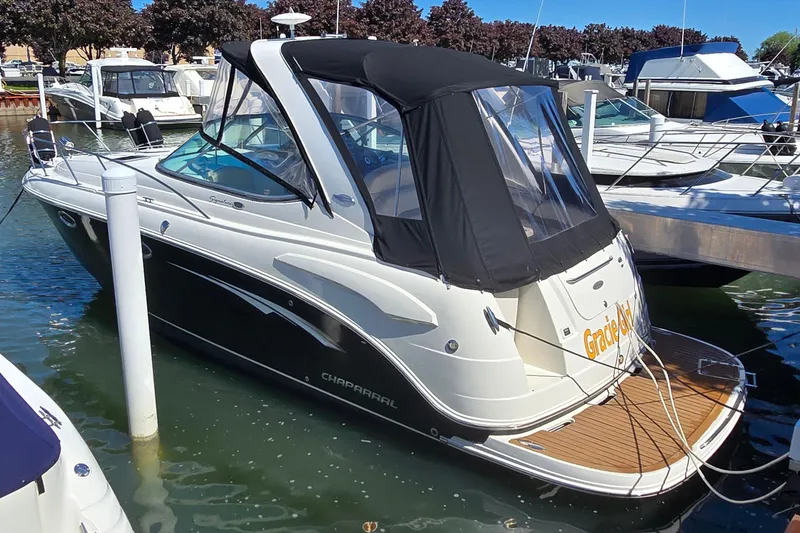 Slide: The Image of 2009 Chaparral Signature 310 boat docked in marina, featuring sleek design and black canopy. - 1
