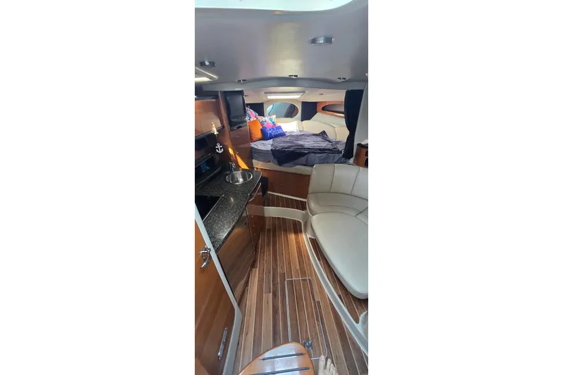 Slide: The Image of 2009 Chaparral Signature 310 interior with wood flooring, kitchenette, and cozy sleeping area. - 16