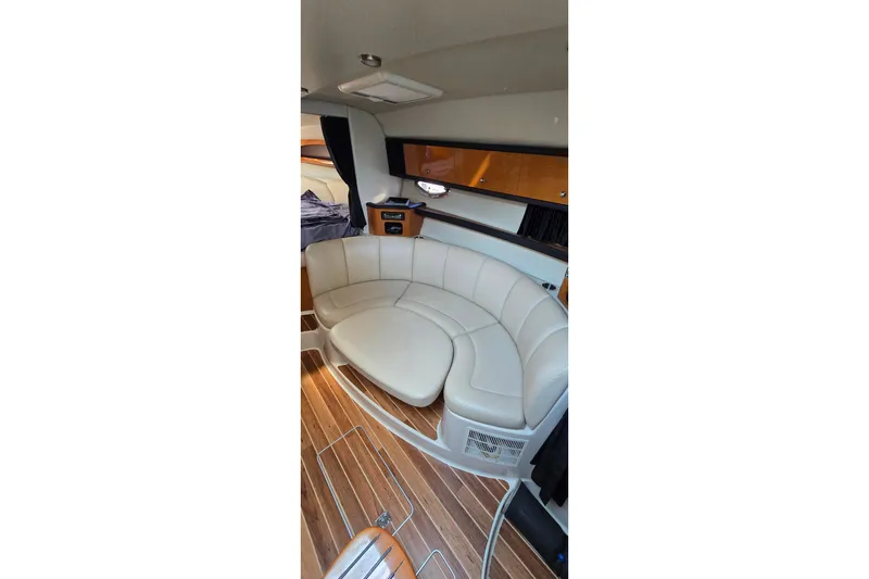 Slide: The Image of Interior of 2009 Chaparral Signature 310 yacht with curved seating and wood flooring. - 17