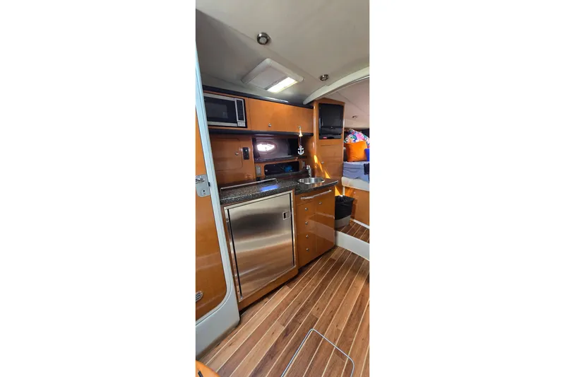 Slide: The Image of 2009 Chaparral Signature 310 yacht interior with kitchenette and wood flooring. - 18