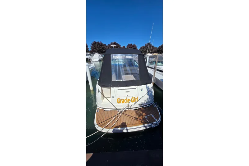 Slide: The Image of 2009 Chaparral Signature 310 boat docked, rear view with canopy and wooden deck. - 2