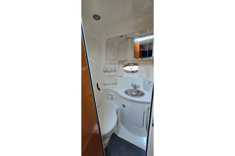 Slide: The Image of 2009 Chaparral Signature 310 boat bathroom with sink, mirror, and toilet. - 22