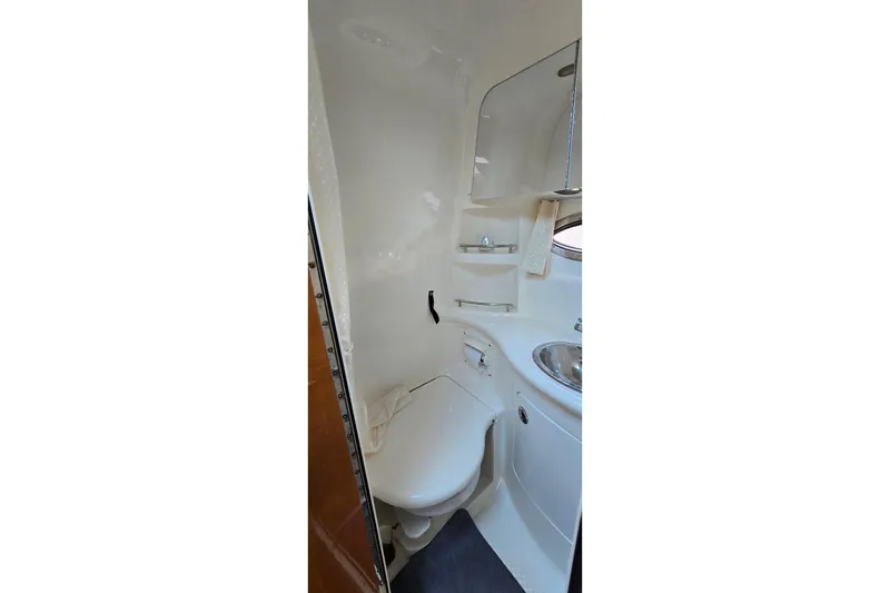 Slide: The Image of 2009 Chaparral Signature 310 boat bathroom with toilet, sink, and mirror. - 23