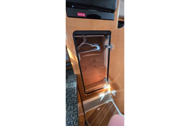 Slide: The Image of Wooden closet with hangers inside a 2009 Chaparral Signature 310 boat interior. - 25