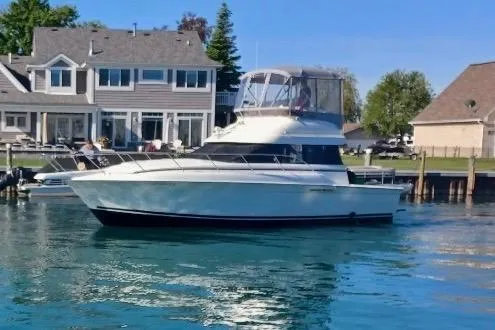 The Image of 1995 Silverton 37 Convertible yacht docked near waterfront homes. - 1