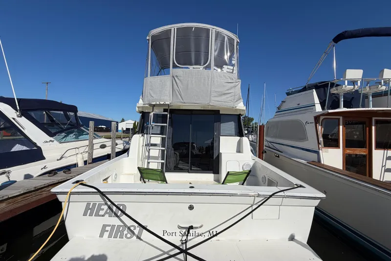 Slide: The Image of 1995 Silverton 37 Convertible boat docked at marina under clear blue sky. - 10