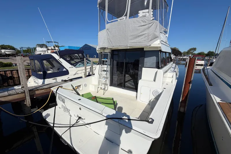 Slide: The Image of 1995 Silverton 37 Convertible yacht docked at marina under clear blue sky. - 11