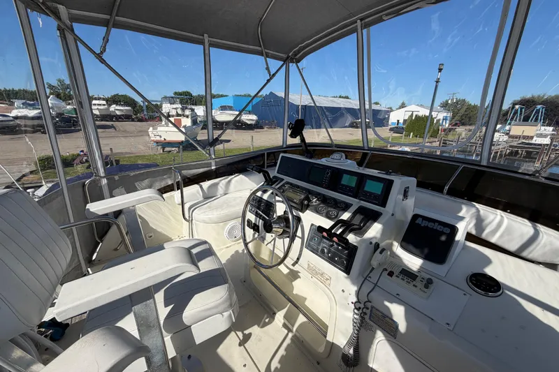 Slide: The Image of 1995 Silverton 37 Convertible boat cockpit with steering wheel and navigation instruments. - 16
