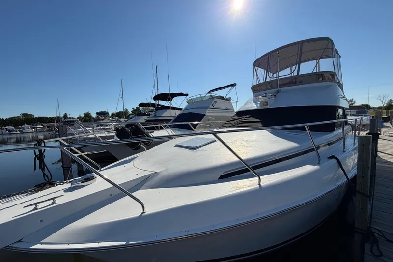 Slide: The Image of 1995 Silverton 37 Convertible yacht docked at marina under clear blue sky. - 2