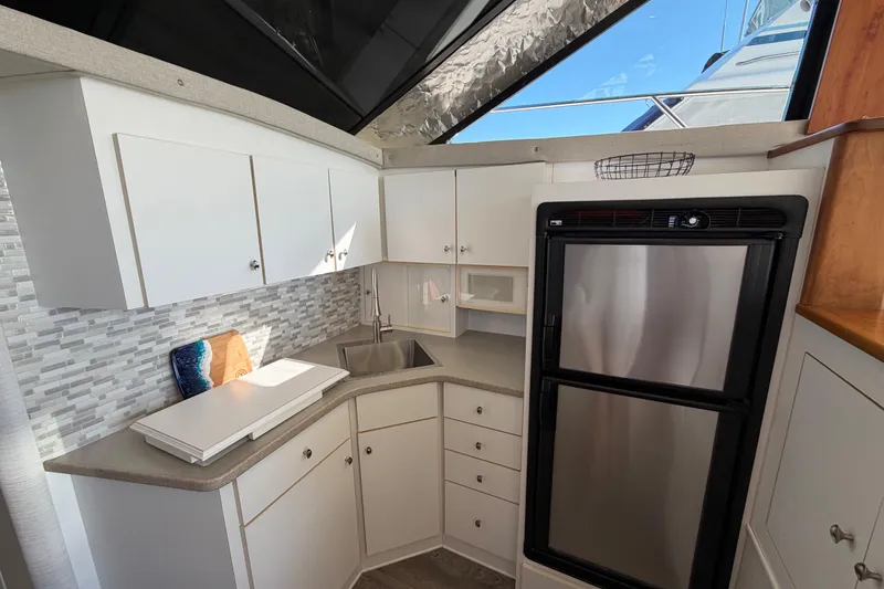 Slide: The Image of 1995 Silverton 37 Convertible yacht kitchen with modern appliances and sleek cabinetry. - 24