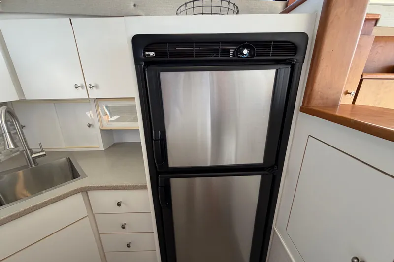 Slide: The Image of Kitchen area of a 1995 Silverton 37 Convertible yacht with stainless steel fridge. - 25