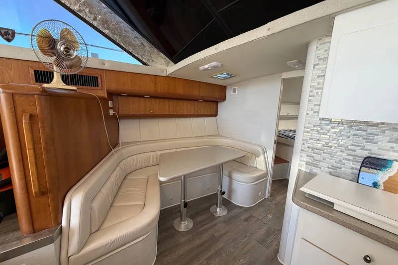 Slide: The Image of Interior of a 1995 Silverton 37 Convertible yacht with a cozy dining area. - 27