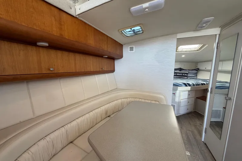 Slide: The Image of Interior of 1995 Silverton 37 Convertible yacht with dining area and cozy sleeping quarters. - 28