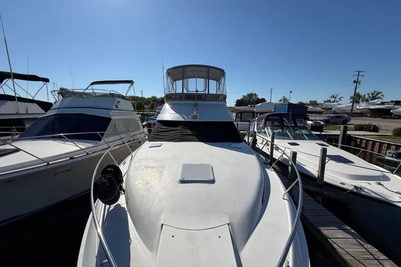 Slide: The Image of 1995 Silverton 37 Convertible yacht docked among other boats under clear blue sky. - 3