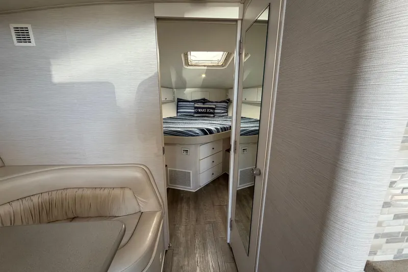 Slide: The Image of Interior of a 1995 Silverton 37 Convertible yacht, featuring a cozy bedroom and seating area. - 30