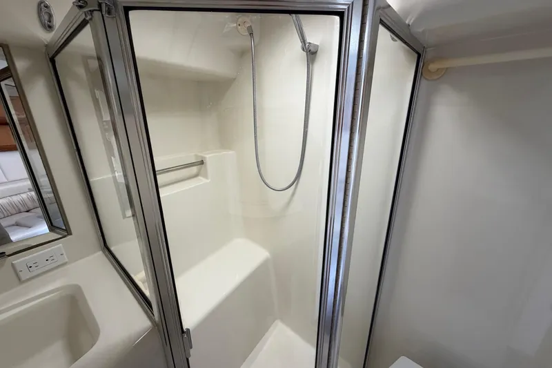 Slide: The Image of Shower area in 1995 Silverton 37 Convertible yacht, featuring glass doors and handheld showerhead. - 36