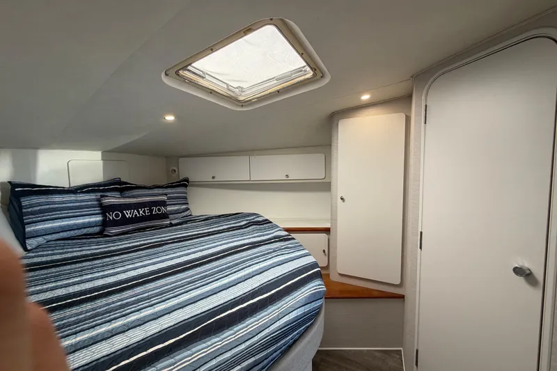 Slide: The Image of Interior cabin of 1995 Silverton 37 Convertible with striped bedding and storage cabinets. - 38