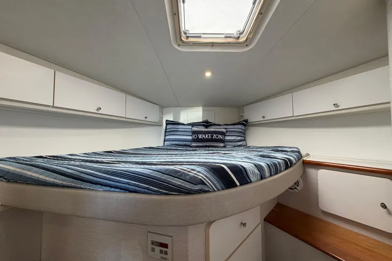 Slide: The Image of Interior cabin of a 1995 Silverton 37 Convertible boat with striped bedding. - 39
