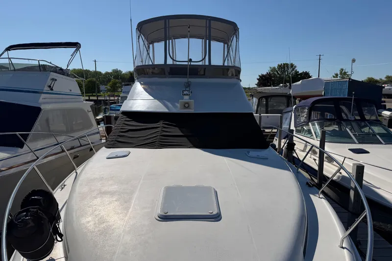 Slide: The Image of 1995 Silverton 37 Convertible yacht docked, featuring a spacious deck and covered flybridge. - 4