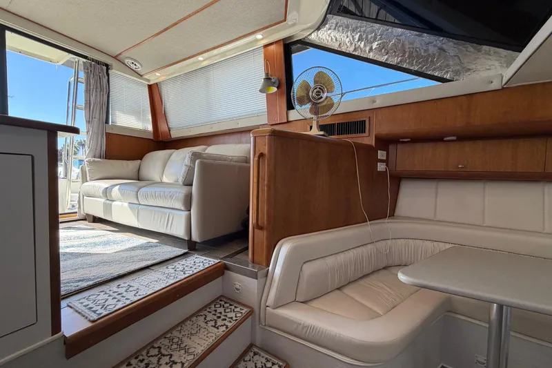 Slide: The Image of Interior of a 1995 Silverton 37 Convertible yacht with cozy seating and natural light. - 42