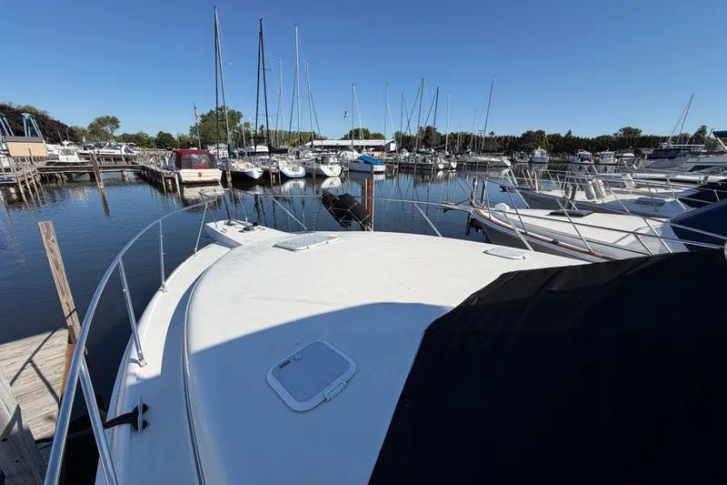 Slide: The Image of 1995 Silverton 37 Convertible yacht docked at a marina with sailboats. - 7
