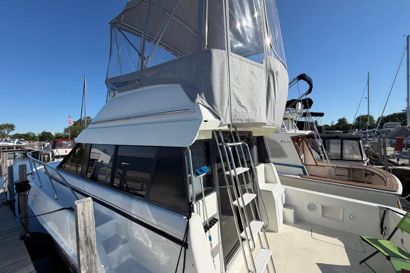 Slide: The Image of 1995 Silverton 37 Convertible yacht docked at marina under clear blue sky. - 8