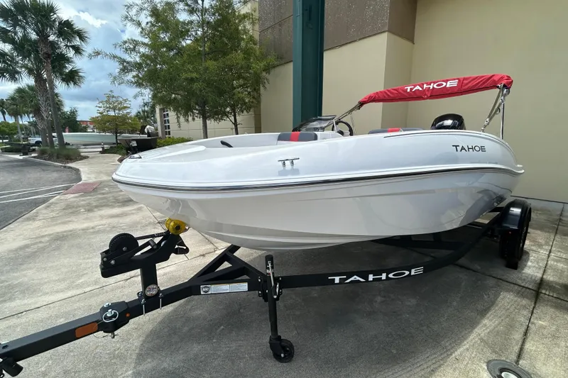 Slide: The Image of 2026 Tahoe T16 boat on trailer with red canopy, parked outdoors. - 3