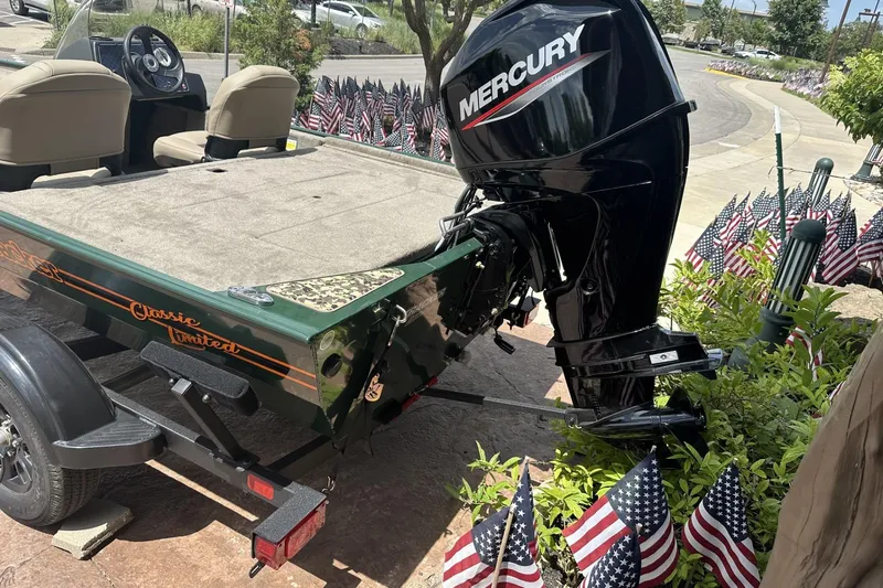 Slide: The Image of 2026 Tracker Bass Tracker Classic Limited boat with Mercury engine, surrounded by American flags. - 3