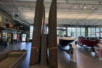 Slide: The Image of 2026 Tracker Grizzly 12 Jon boats displayed in a showroom with other boats. - 3