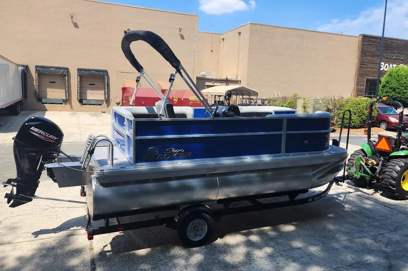 Slide: The Image of 2026 Sun Tracker Party Barge 16 DLX pontoon boat with Mercury outboard motor on trailer. - 2