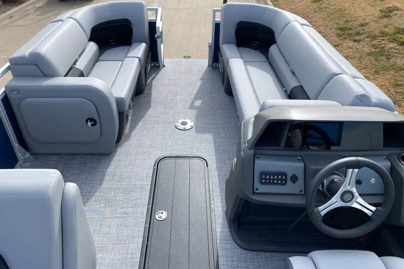 Slide: The Image of 2026 Sun Tracker SportFish 22 XP3 pontoon boat interior with gray seating and steering console. - 2