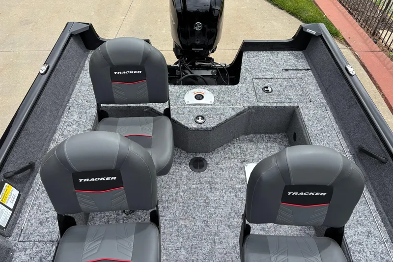 Slide: The Image of 2026 Tracker Pro Guide V-16 SC boat interior with four gray seats and motor. - 5