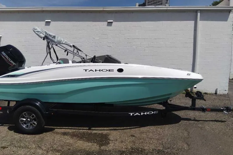 Slide: The Image of 2026 Tahoe T16 boat on trailer, white and teal design, parked outdoors. - 1