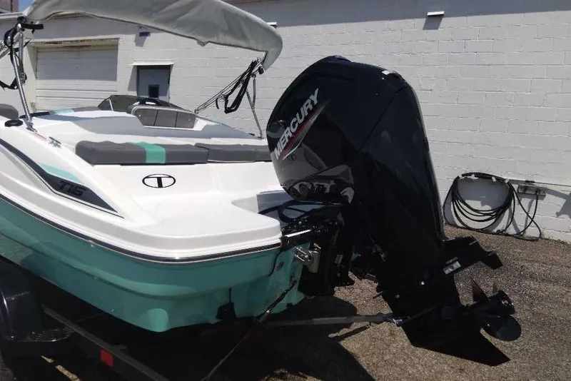 Slide: The Image of 2026 Tahoe T16 boat with Mercury outboard motor, parked outdoors. - 14