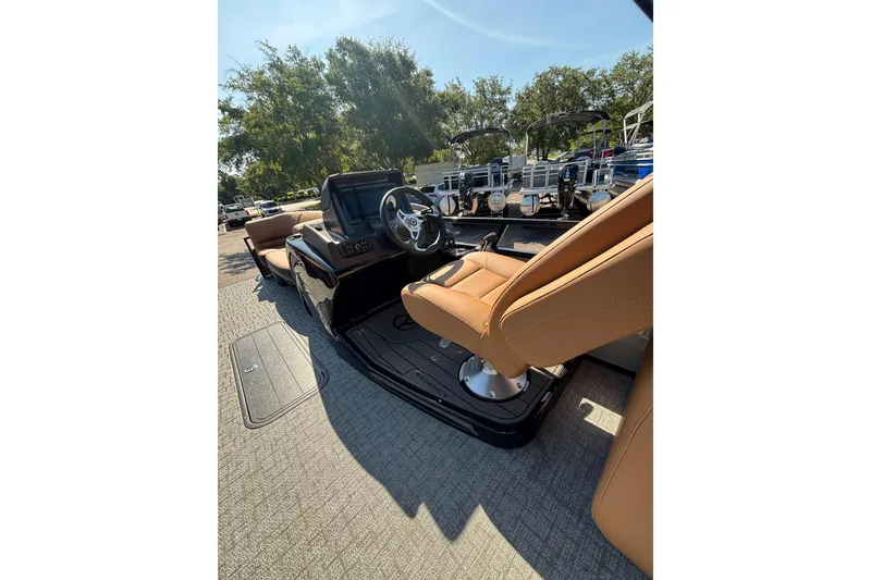 Slide: The Image of 2026 Regency 230 DL boat interior with tan seating and modern steering console. - 2