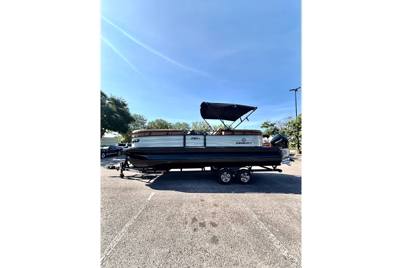 Slide: The Image of 2026 Regency 230 DL pontoon boat on trailer under clear blue sky. - 4