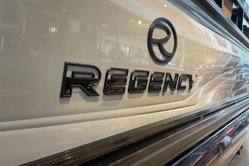 Slide: The Image of 2026 Regency 230 DL boat logo on sleek exterior surface. - 13