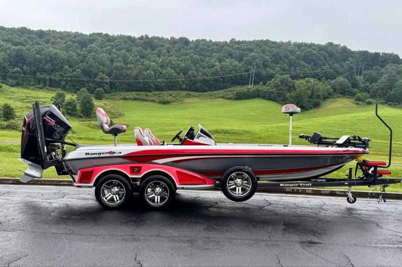 Slide: The Image of 2026 Ranger Z521R Cup-Equipped boat on trailer, parked with lush green hills in background. - 23