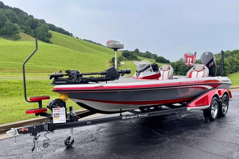 Slide: The Image of 2026 Ranger Z521R Cup-Equipped boat on trailer, parked on paved road with grassy hills. - 25