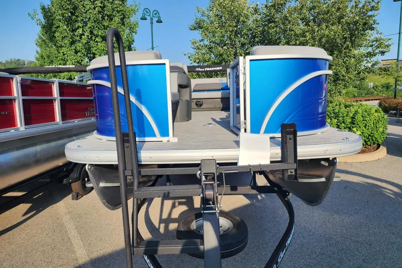 Slide: The Image of 2026 Sun Tracker Party Barge 22 RF DLX pontoon boat on trailer, parked outdoors. - 5