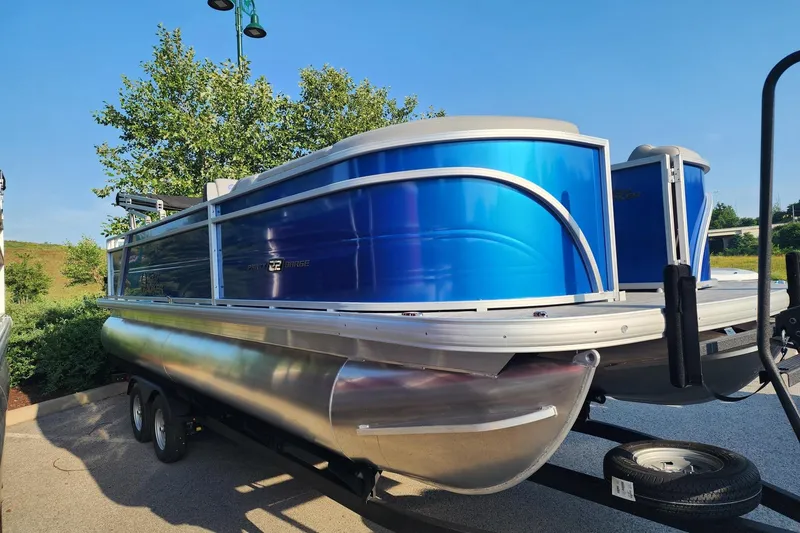 Slide: The Image of 2026 Sun Tracker Party Barge 22 RF DLX pontoon boat with vibrant blue exterior. - 1